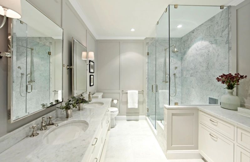 Elegant bathroom remodel with marble tile, glass shower enclosure, and dual vanity in Tampa Bay